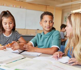 three kids working at a desk