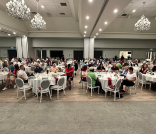 People sitting at tables in a big room