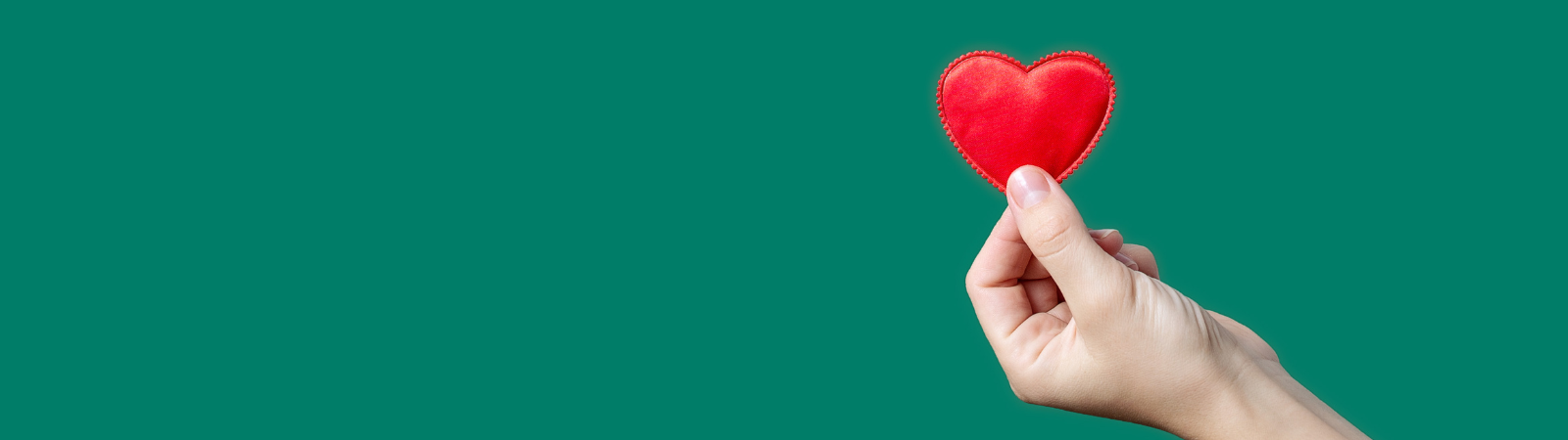 Person holding a red paper heart